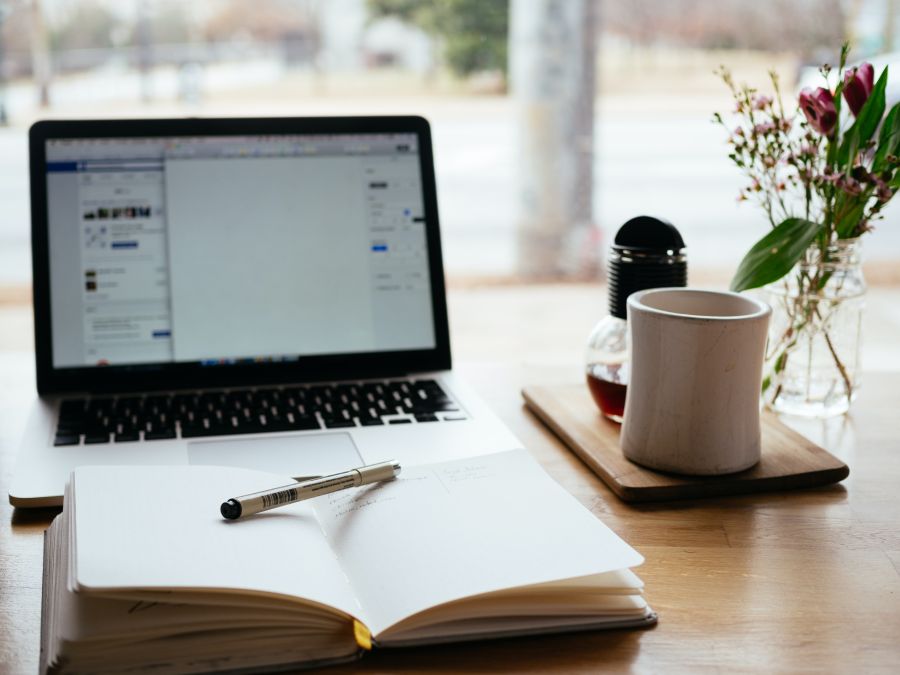 an open laptop and notebook of someone trying to write SEO content