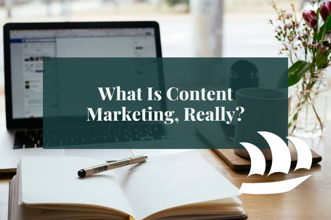 an open notebook in front of a laptop with overlaid text saying "what is content marketing, really?"